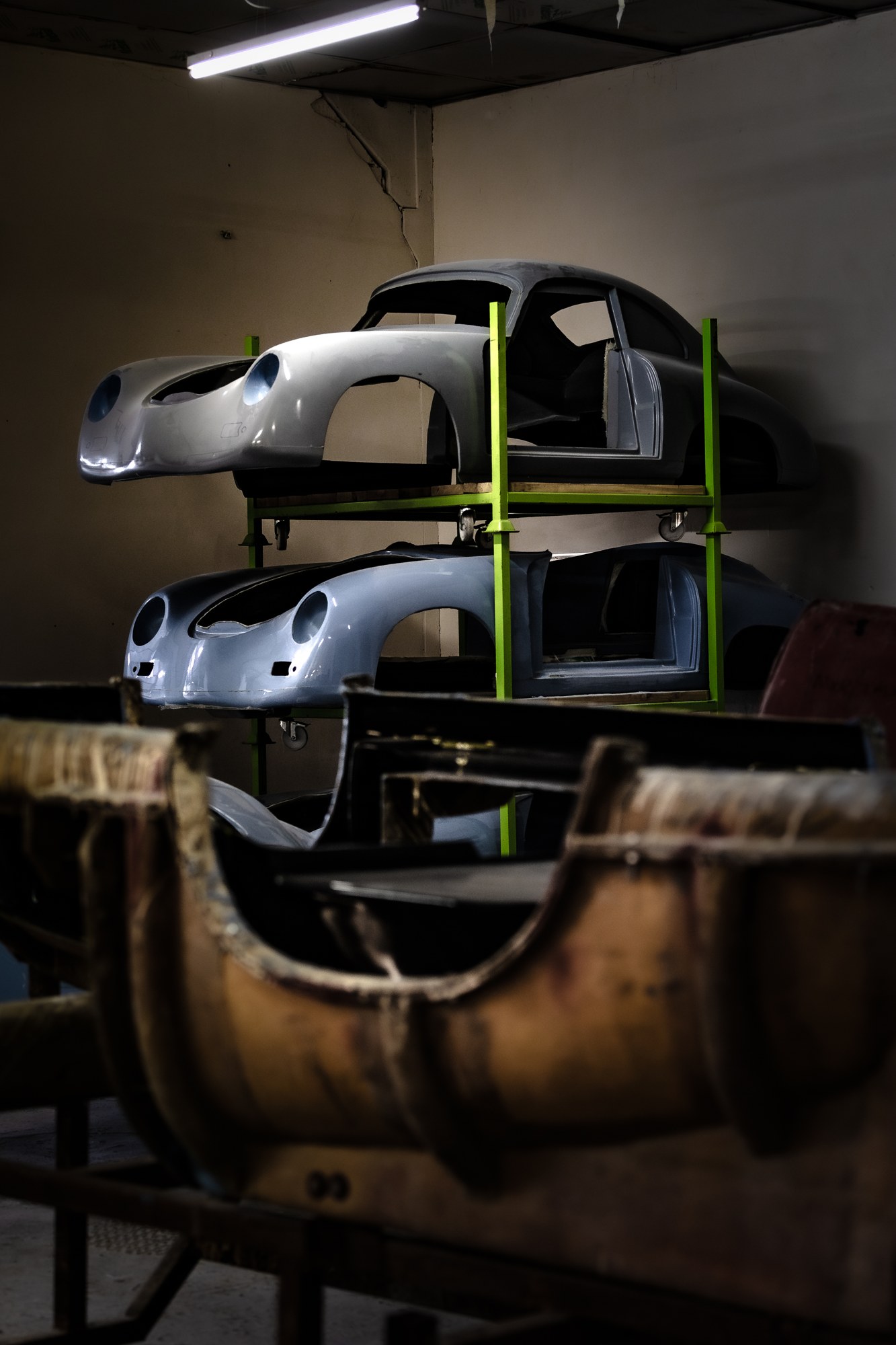 Composite sports car body shells on workshop racks